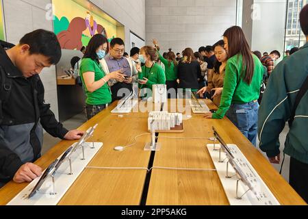 SHANGHAI, CINA - 22 APRILE 2023 - i dipendenti indossano abiti verdi per servire i clienti in un APPLE Store di Shanghai, Cina, 22 aprile 2023. Sull'esterno Foto Stock