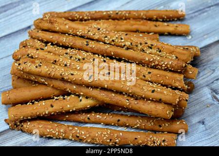 Mucchio di grissini, anche noti come grissini, grissino o bastoncini da immersione, bastoncini a matita di pane fresco e secco salato al forno con cumino e Wi coperto Foto Stock