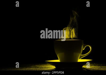 Una tazza con una bevanda calda e vapore illuminato da luce gialla, spazio copia, creativo. Tazza da caffè fumante su sfondo nero, silhouette. Mattina co Foto Stock