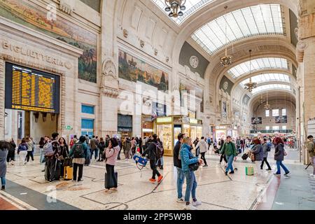 Persone che camminano attraverso il magnifico interno della sala d'ingresso al piano terra della stazione ferroviaria di Milano Centrale a Milano, Italia Foto Stock