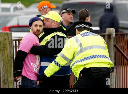 Gli attivisti di Animal Rising sono rapprehended dagli ufficiali di polizia mentre tentavano di invadere il corso di gara durante il Coral Scottish Grand National Festival all'ippodromo di Ayr. Data immagine: Sabato 22 aprile 2023. Foto Stock