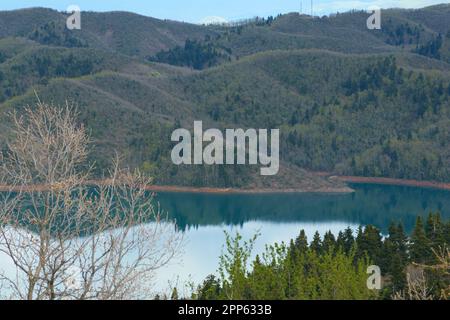 Spettacolare vista di un lago tranquillo immerso tra torreggianti catene montuose Foto Stock