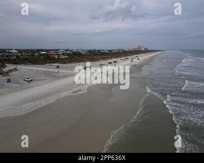 Una vista aerea di una affollata spiaggia tropicale in una giornata nuvolosa a New Smyrna Beach, Florida Foto Stock