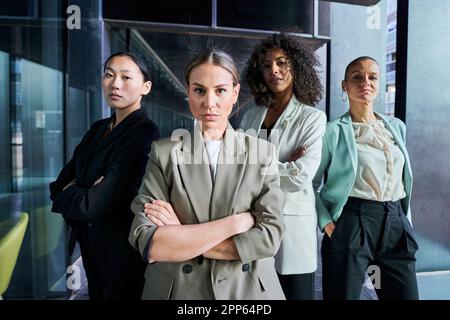 Quattro donne multirazziali che guardano la telecamera sicura e seria in ufficio. Foto Stock