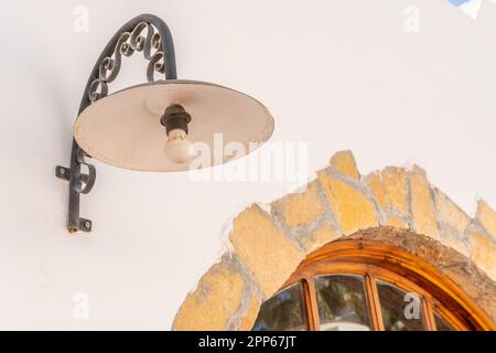 Vecchia lampada sul muro di pietra bianca. Foto Stock