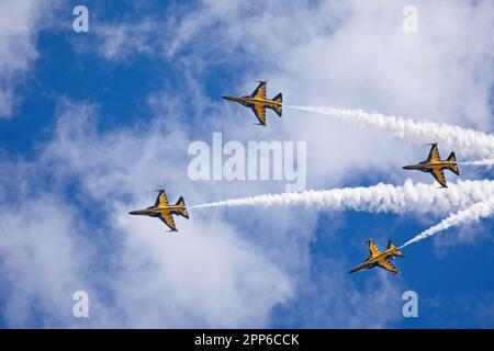 Quattro jet militari si innalzano attraverso il cielo in formazione, lasciando dietro di loro tracce di fumo bianco Foto Stock
