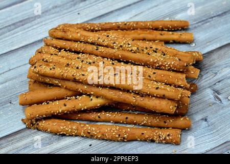 Mucchio di grissini, anche noti come grissini, grissino o bastoncini da immersione, bastoncini a matita di pane fresco e secco salato al forno con cumino e Wi coperto Foto Stock