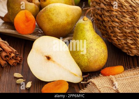 pera gialla tagliata su fondo di legno Foto Stock