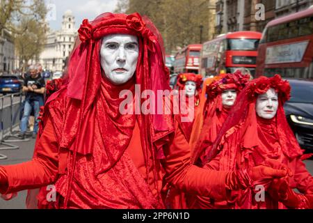 Londra, Regno Unito - 22nd aprile 2023: La Brigata del Red Rebel si mostra fuori da Parliament Square. La ribellione di estinzione e altri gruppi di campagna sono il secondo giorno di una protesta di quattro giorni in Piazza del Parlamento. I manifestanti hanno dichiarato che intensificheranno le loro azioni se il governo britannico non soddisferà le due richieste di cambiamento climatico entro le 5 di martedì 24th aprile. Gli attivisti chiedono la fine di tutte le licenze, i finanziamenti e l'approvazione di nuovi progetti nel settore del petrolio e del gas, nonché la creazione di "assemblee di cittadini d'emergenza” per affrontare la crisi climatica. Credito: Sinai Noor/Ala Foto Stock