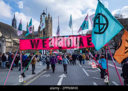 Londra, Regno Unito. 22 aprile 2023. Un gigantesco banner di benvenuto fuori dalle Camere del Parlamento, eretto da attivisti della rivolta di estinzione (XR) e da gruppi partner che si sono Uniti in una protesta nota come “il Grande”, Il secondo dei quattro giorni di attivismo a Westminster e nei dintorni per sensibilizzare gli Stati membri sugli effetti del cambiamento climatico e sulla necessità di un'azione urgente da parte del governo. Credit: Stephen Chung / Alamy Live News Foto Stock