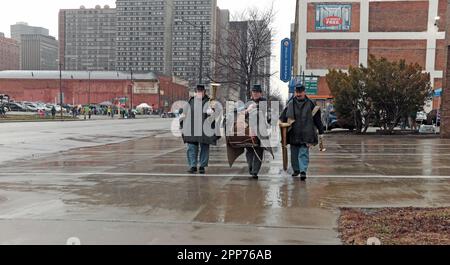 I musicisti portano i loro strumenti sotto la pioggia mentre si dirigono verso la sfilata per la 2023 St Patrick's Day Parade nel centro di Cleveland, Ohio, Stati Uniti. Il primo ufficiale di St. La parata del giorno di Patrick a Cleveland si è tenuta nel 1867, rendendola una delle più antiche del paese e attrae centinaia di migliaia di festaioli ogni anno. Foto Stock