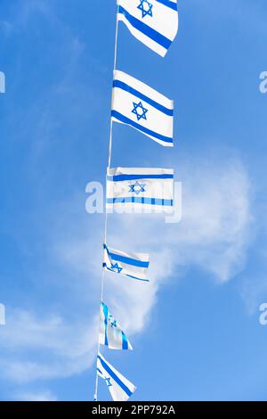 Israele bandiera bunting che batte contro uno sfondo di cielo blu con nuvole bianche nel giorno di indipendenza di Israele. Foto Stock