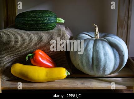 Zucche, midollo vegetale e pepe dolce in cucina, annata vita morta di cibo biologico. Foto delle zucchine sugli scaffali in interni rustici. Che Foto Stock