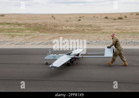 Il personale della guardia nazionale dell'esercito dell'Oregon Sgt. Timothy Powers spinge un sistema di aerei senza equipaggio tattico ombra RQ-7B dopo che è atterrato durante un volo dimostrativo come parte dell'apertura ufficiale della struttura operativa del sistema aereo senza equipaggio a Boardman, Oregon, il 21 aprile 2023. Il progetto da $13,3 milioni di dollari comprende un parcheggio per veicoli organizzativi pavimentato e una pista, un impianto per rifiuti controllati e impianti per materiali infiammabili, oltre a un impianto di volo tattico senza equipaggio e una gamma di mitragliatrici. (Foto della Guardia Nazionale di John Hughel, Oregon Military Department Public Affairs) Foto Stock