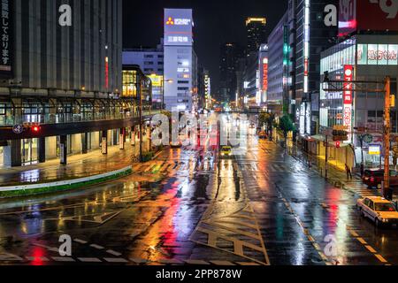 Osaka, Giappone - 12 aprile 2023: Le luci si riflettono sulle strade bagnate del centro di Osaka nella notte delle piogge Foto Stock