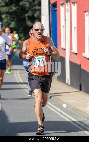 Vecchio corridore del club Jaffa che gareggia nella gara di strada di Framlingham Flyers 10km Foto Stock