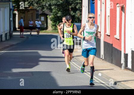 I concorrenti della gara su strada 10km dei Framlingham Flyers corrono leggermente in salita Foto Stock