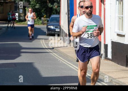 I concorrenti della gara su strada 10km dei Framlingham Flyers corrono leggermente in salita Foto Stock