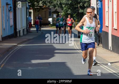 I concorrenti della gara su strada 10km dei Framlingham Flyers corrono leggermente in salita Foto Stock