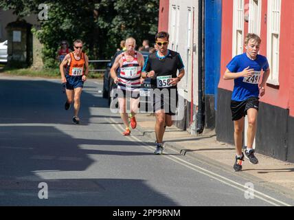 I concorrenti della gara su strada 10km dei Framlingham Flyers corrono leggermente in salita Foto Stock