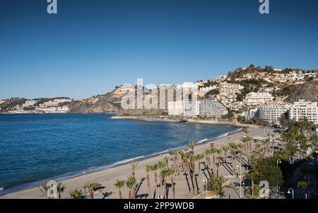 Vista panoramica della spiaggia di Almunecar e del paesaggio costiero, con moderni edifici turistici e il mare azzurro a Granada, Spagna Foto Stock