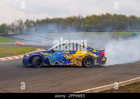 AGRE Group BMW M3 brucia gomma e gomme urlanti al circuito Three Sisters Race Circuit di Wigan, Lancashire, Regno Unito Foto Stock