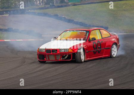 BMW Car No.99 brucia gomma e gomme urlanti al Three Sisters Race Circuitin Wigan, Lancashire UK Foto Stock