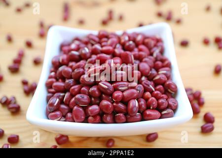 Primo piano di una pila di fagioli rossi Adzuki secchi in una ciotola bianca Foto Stock