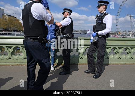 Londra, Inghilterra, Regno Unito. Agenti di polizia che effettuano un'operazione contro i commercianti illegali sul ponte di Westminster. Aprile 2023 Foto Stock