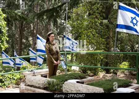 Gerusalemme, Israele. 23rd Apr, 2023. I soldati dell'IDF posano piccole bandiere israeliane con nastri neri su ciascuna delle tombe e salutano i caduti al cimitero militare del Monte Herzl prima del Memorial Day, Yom Hazikaron, per i soldati caduti di Israele e le vittime degli attacchi terroristici. Il Memorial Day sarà segnato il 24th aprile 2023. Credit: NIR Alon/Alamy Live News Foto Stock