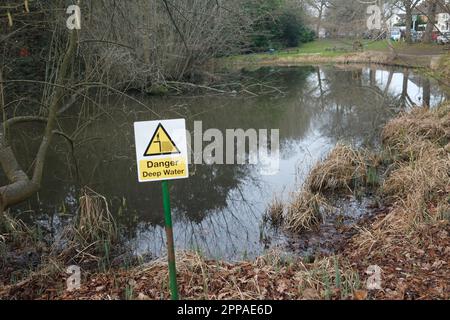 Un segnale di avvertimento che consiglia alla gente di prendersi cura di uno stagno di acque profonde nel villaggio di Letchmore Heath Hertfordshire. Attenzione ai bambini!! Foto Stock