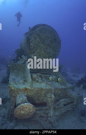 Resti di una locomotiva a vapore sulla seconda guerra mondiale, relitto. Subacquei in background. Sito di immersione relitto Thistlegorm, Sinai, Egitto, Mar Rosso Foto Stock