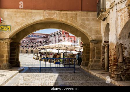 Badajoz, Spagna - 24 giugno 2022: Facciate di edifici colorati e case in alta piazza a Badajoz visto da sotto l'arco del peso (Spagna) Foto Stock