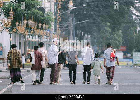 I giovani indonesiani stanno camminando nel mezzo di Via Kayoetangan dopo aver fatto la preghiera di Sholat IED o IED Mubarak con sfondo bokeh Foto Stock