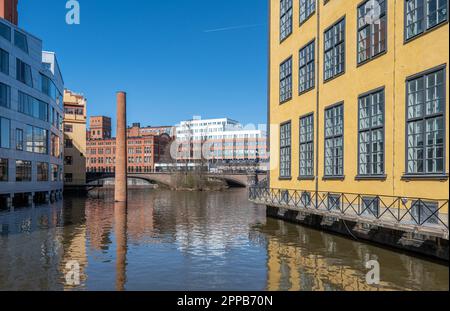 L'iconico edificio Flatiron nel paesaggio industriale e nel fiume Motala in una soleggiata giornata primaverile. Norrkoping è una storica città industriale della Svezia. Foto Stock