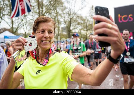 Londra, Regno Unito. 23 aprile 2023. Un corridore prende un selfie con la sua medaglia al termine della TCS London Marathon. 45.000 atleti d'élite, corridori di club e corridori di divertimento stanno partecipando al popolare evento annuale di massa che raccoglie grandi quantità per gli enti di beneficenza. Credit: Stephen Chung / EMPICS / Alamy Live News Foto Stock