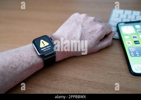 Smart Watch di una persona che visualizza un messaggio di testo di avviso del server governativo del Regno Unito. Il testo avverte la popolazione britannica di possibili emergenze e minacce Foto Stock