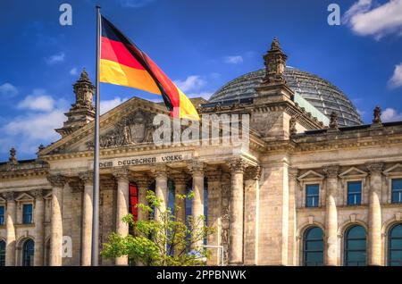 L'edificio del Reichstag nella città di Berlino. La bandiera della Repubblica federale di Germania sventola davanti al parlamento nazionale tedesco. Foto Stock