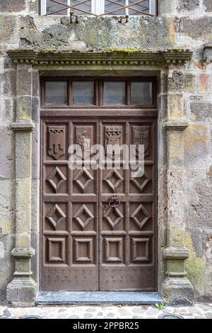 Vecchia porta rustica in legno, nella città di Salers in Alvernia, Francia Foto Stock