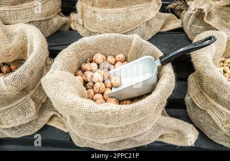 Le noci non pelate in una borsa di tela sono vendute in un negozio Foto Stock