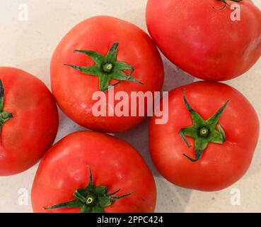 Pomodori rossi su un tavolo bianco visto direttamente dall'alto Foto Stock