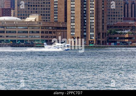 Il Tropic Oceans Airways Cessna 208B decade dalla base degli idrovolanti dello Skyports di New York sull'East River. Sfondo: Waterside Plaza Foto Stock