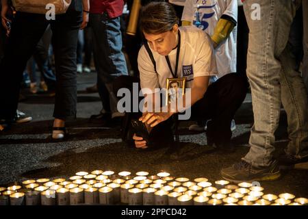 Israele. 22nd Apr, 2023. Un membro della famiglia perquisito porta con sé una foto della sua amata accanto a migliaia di candele “Yom HaZikaron” per la Giornata commemorativa dei soldati caduti israeliani e delle vittime degli attacchi terroristici durante una protesta contro la revisione giudiziaria a Tel Aviv. Apr 22th 2023. (Matan Golan/Sipa USA). Credit: Sipa USA/Alamy Live News Foto Stock