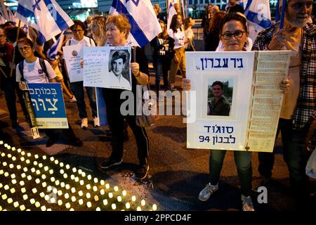 Israele. 22nd Apr, 2023. I membri della famiglia in lutto tengono una foto dei loro cari accanto a migliaia di candele “Yom HaZikaron” per la Giornata commemorativa dei soldati caduti israeliani e delle vittime degli attacchi terroristici durante una protesta contro la revisione giudiziaria a Tel Aviv. Apr 22th 2023. (Usi Matan Golan/Sipa). Credit: Sipa USA/Alamy Live News Foto Stock