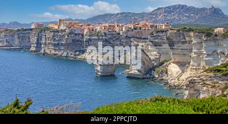 Bonifacio si trova sulle scogliere di una penisola calcarea scolpita ed erosa dal mare, con edifici che sovrastano il bordo, Corsica, Francia Foto Stock