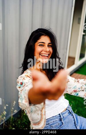 Donna felice godendo fuori casa contenitore Foto Stock