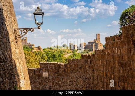 Italia, Lazio, Tuscania, Vista della chiesa di San Pietro in estate con le mura in primo piano Foto Stock