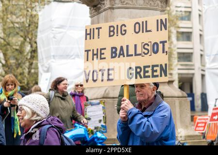 L'uomo tiene il cartello di protesta 'Vota Verde' al di fuori del dipartimento per il Commercio e l'industria, parte del Picket popolare, la ribellione di estinzione Big One, 2023. Foto Stock