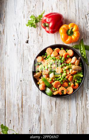 Peperoni crudi e verdure tritate in ciotola Foto Stock