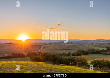 Italia, Toscana, Castiglione d'Orcia, Sole che sorge sulla Val d'Orcia Foto Stock